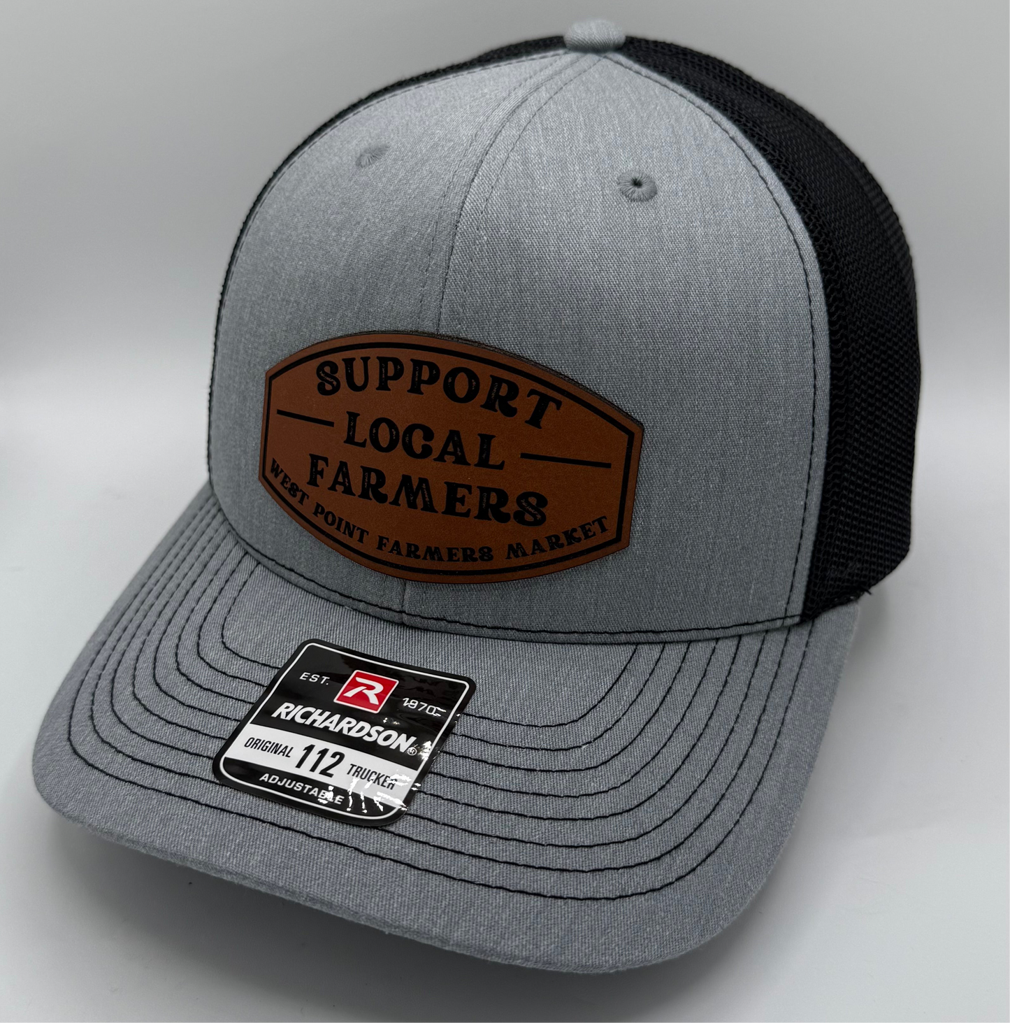Heather grey and black trucker hat with curved bill and leather patch for customization