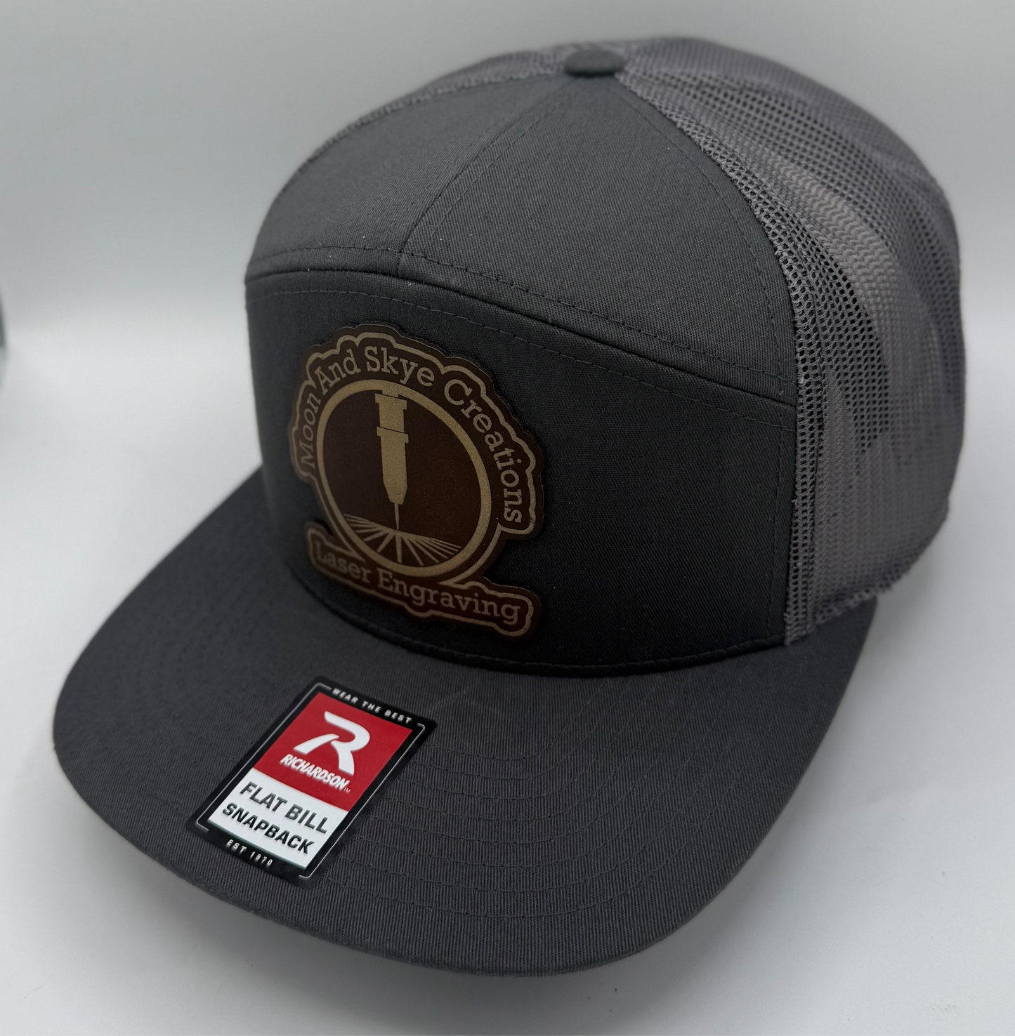 Richardson 168 7-panel trucker hat in dark charcoal with charcoal mesh back and flat bill, perfect for custom leather patch branding.