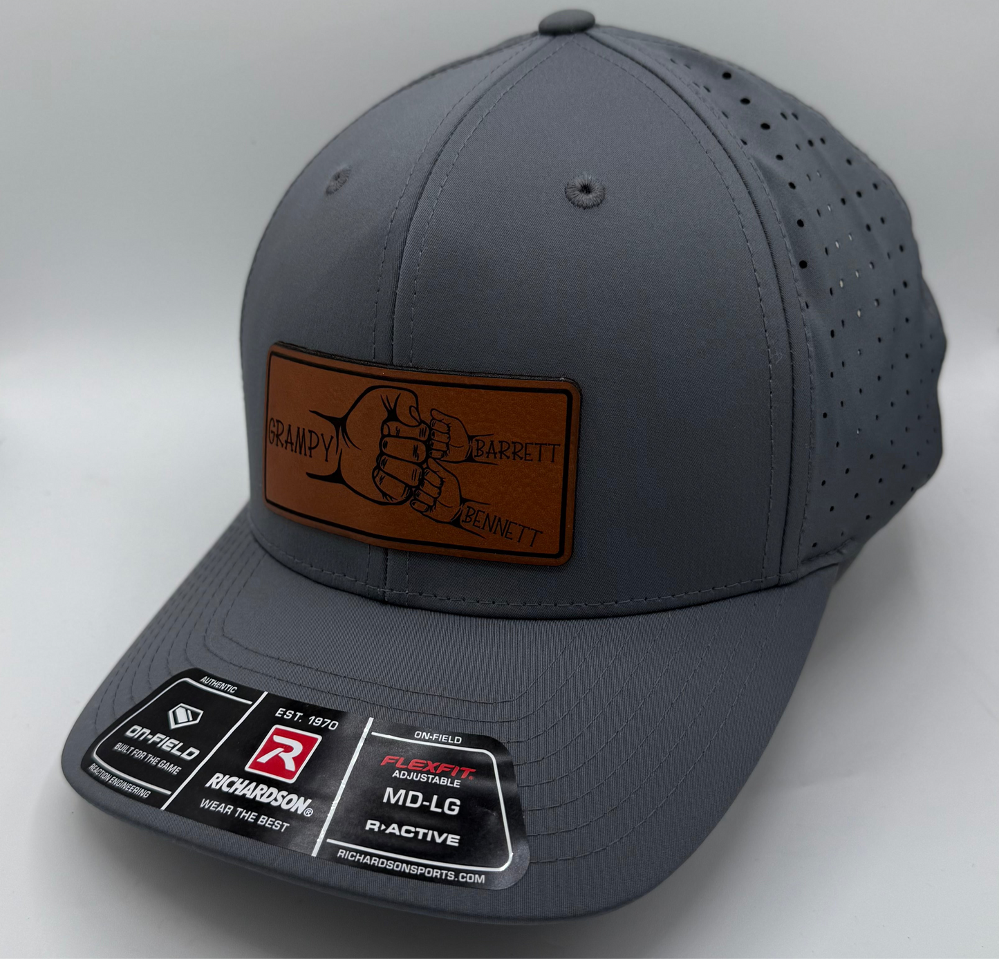 Richardson laser perforated snapback hat in solid charcoal with curved bill and breathable side panels, ideal for custom leather patch branding.
