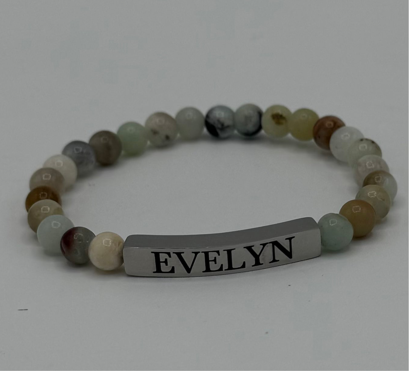 "Stunning Amazonite bracelet by Moon and Skye Creations, featuring soothing green and earthy-toned natural stones, elegantly complemented by a sleek silver bar for customization. A perfect blend of tranquility and style, ideal for meaningful personalization and everyday wear."