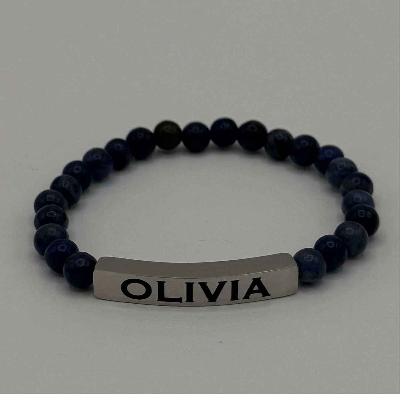 "Elegant Sodalite bracelet by Moon and Skye Creations, featuring deep blue natural stones paired with a sleek silver bar for personalization. This handcrafted piece exudes sophistication and individuality, making it a perfect meaningful accessory for any occasion."