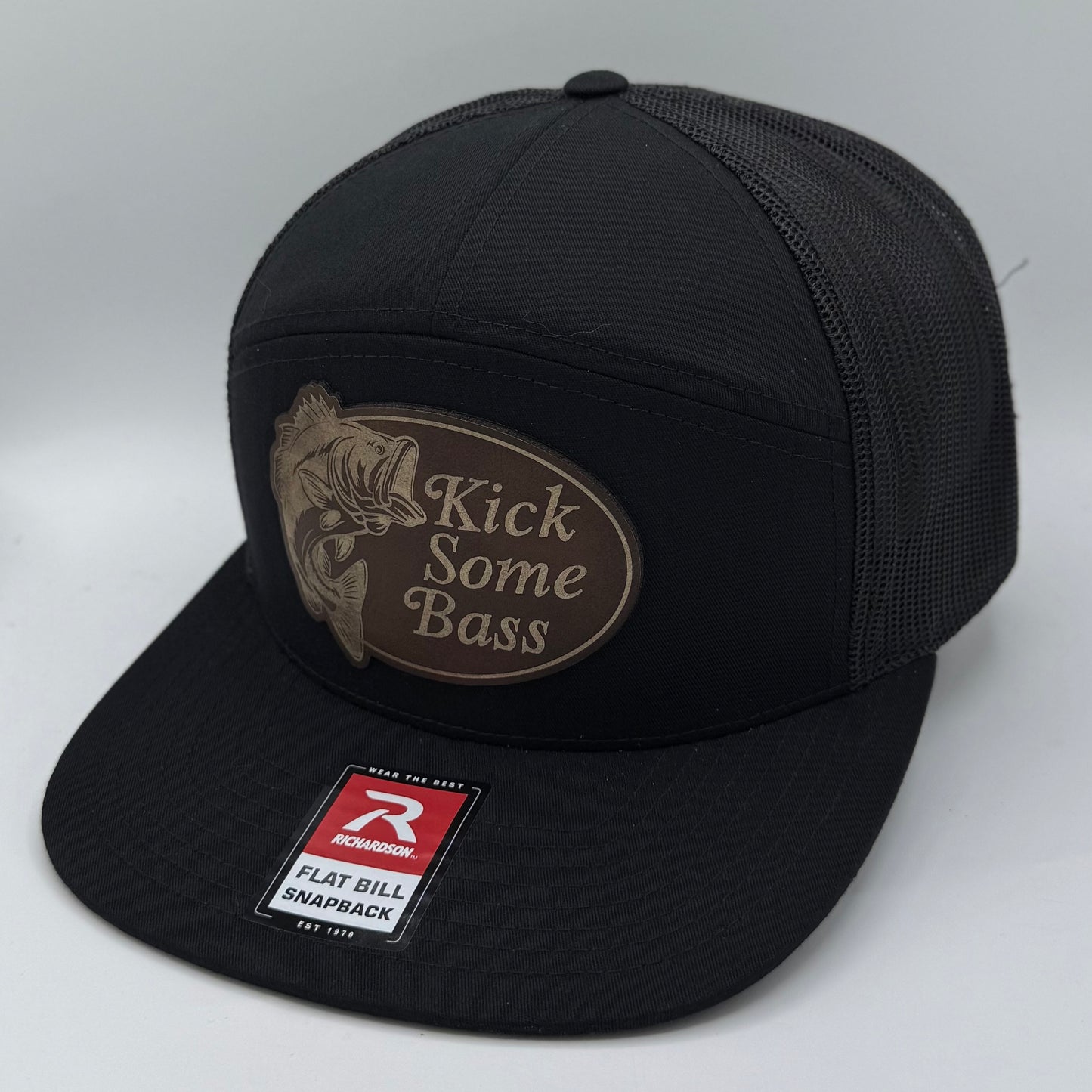 Richardson 168 7-panel trucker hat in solid black with black mesh back and flat bill, perfect for custom leather patch branding.