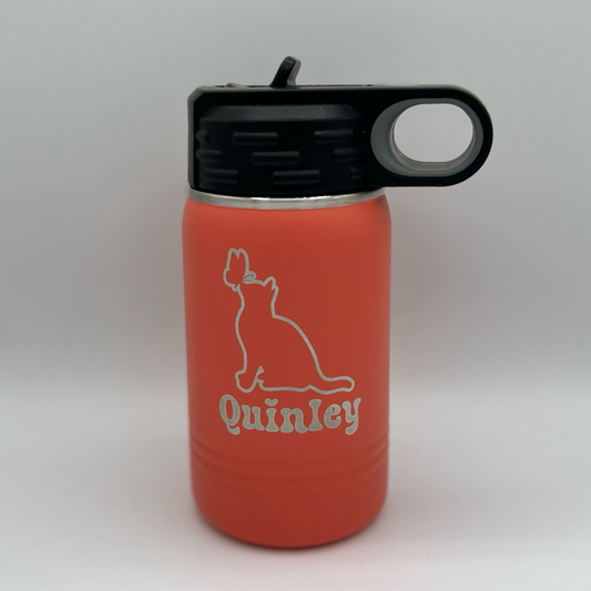 "Custom personalized coral Polar Camel 12oz stainless steel kids' water bottle with a black flip-top lid and handle. The bottle features an engraved design of a cat gazing at a butterfly, along with the name 'Quinley' in a playful, bold font."