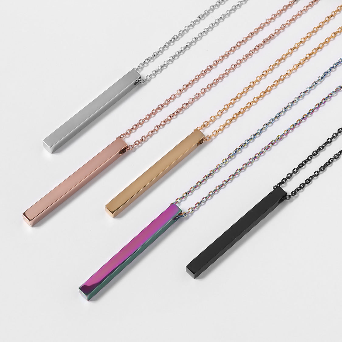 "Personalized vertical bar necklaces in various finishes, including silver, rose gold, gold, black, and iridescent rainbow. These sleek and modern pendant necklaces are customizable with engravings, making them a stylish and meaningful accessory for any occasion."